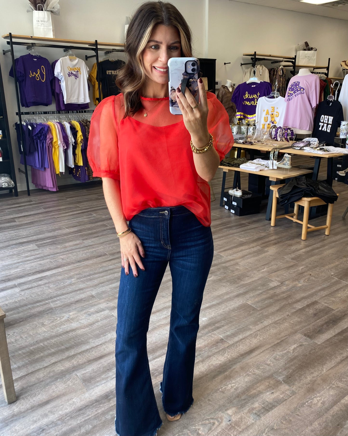 Red sheer top with red camisole underneath. Blouse has a tie back and puff sleeve
