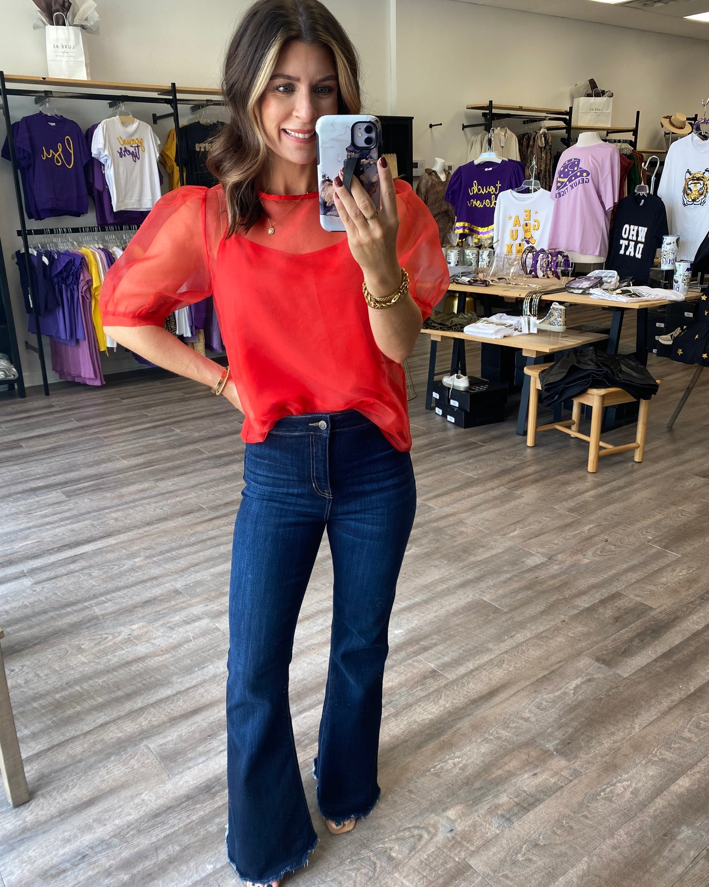 Red sheer top with red camisole underneath. Blouse has a tie back and puff sleeve