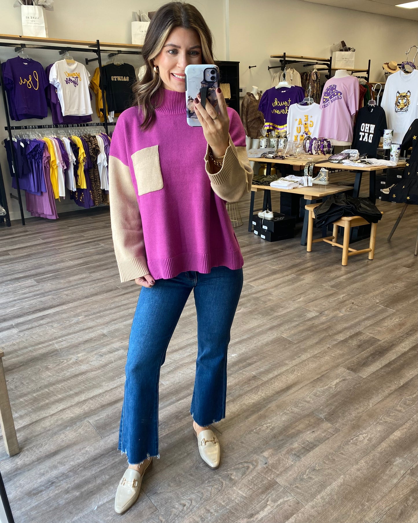 A coloblock sweater with a magenta bodice and tan sleeves with a tan pocket on the chest.