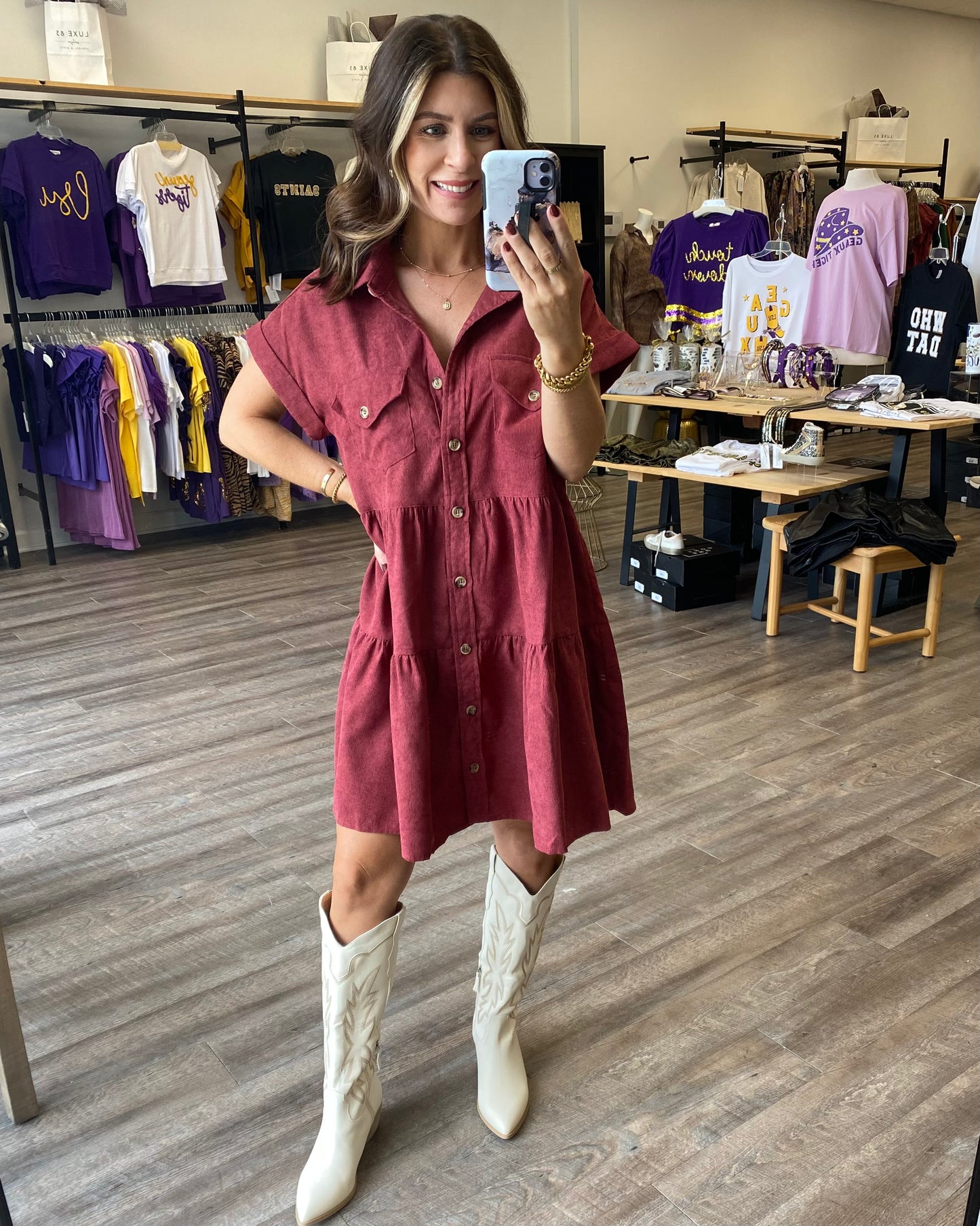 A merlot or wine colored corduroy dress with a babydoll style fit. The dress is a button front and is tiered.