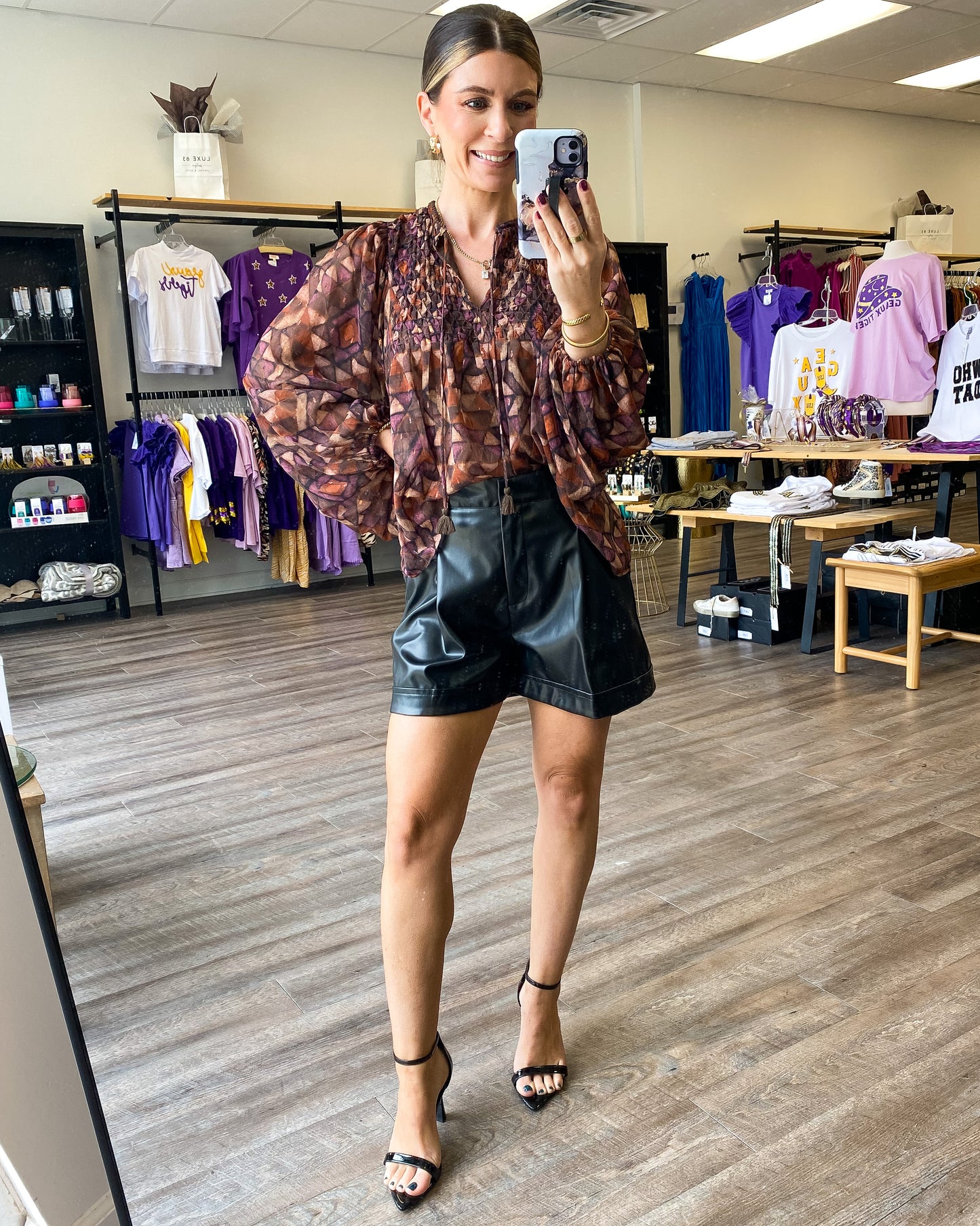 A brown and neutral top with all over print with smocked detail around the neckline and sheer balloon sleeves.