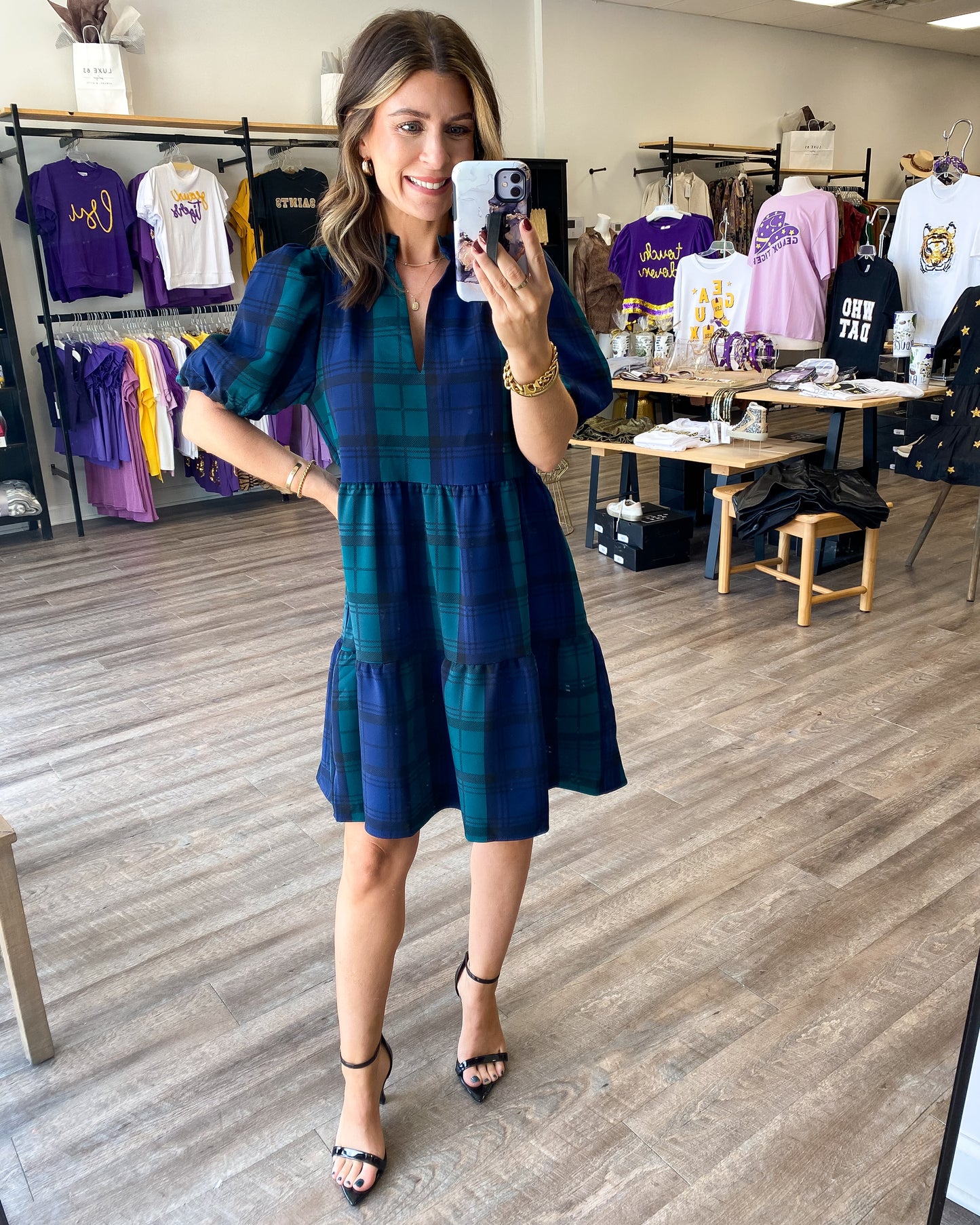 A babydoll style dress in a green and navy blue plaid print.