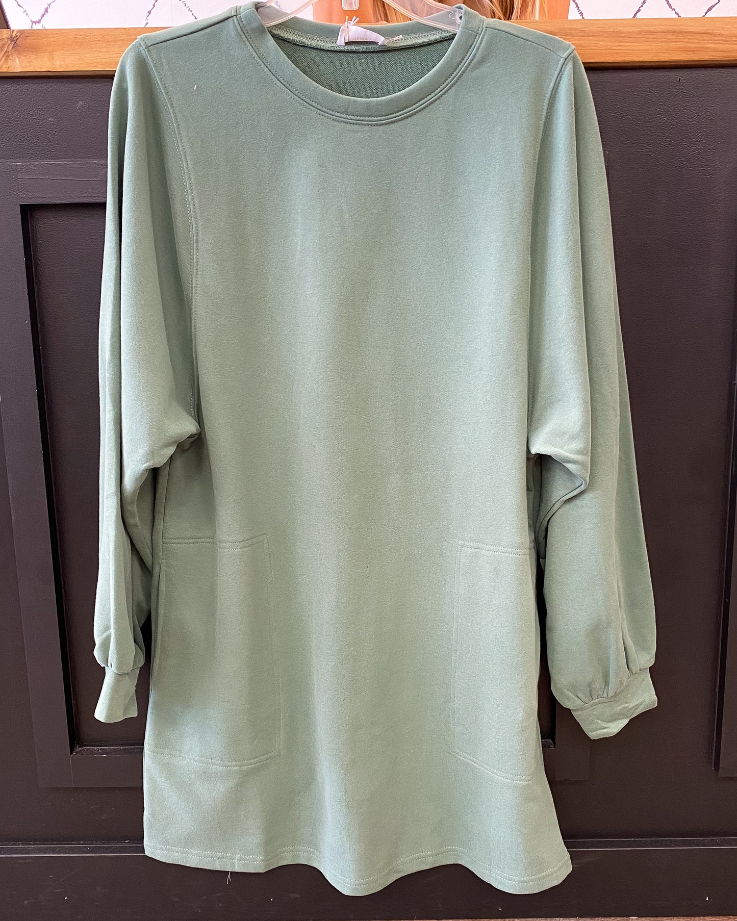 A knee length dress made of sweatshirt material with pockets at the hips in three colors -- camel, charcoal, and green