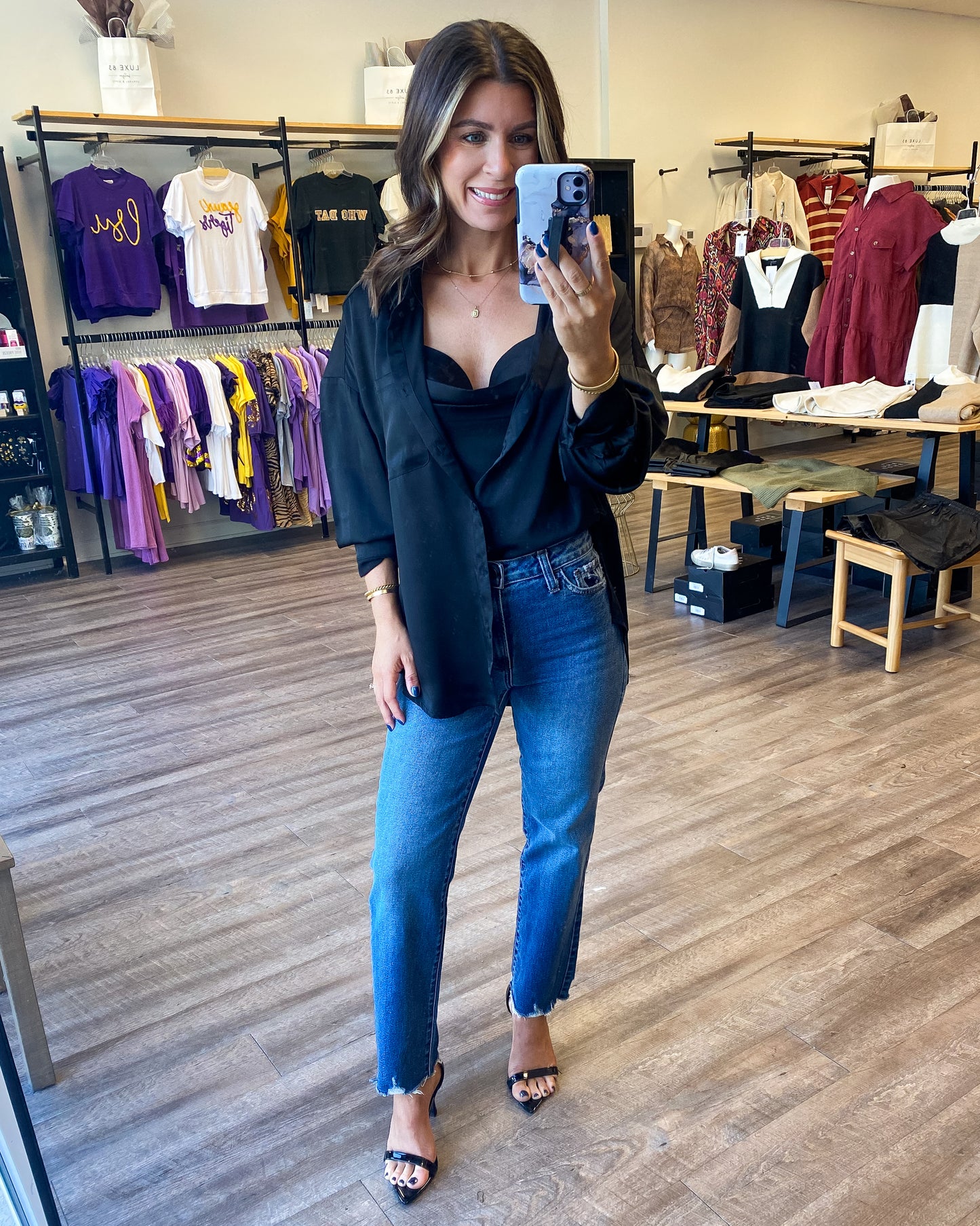 Model is photographed wearing a button down black silky shirt paired with the included black camisole underneath. The camisole is slightly cropped.