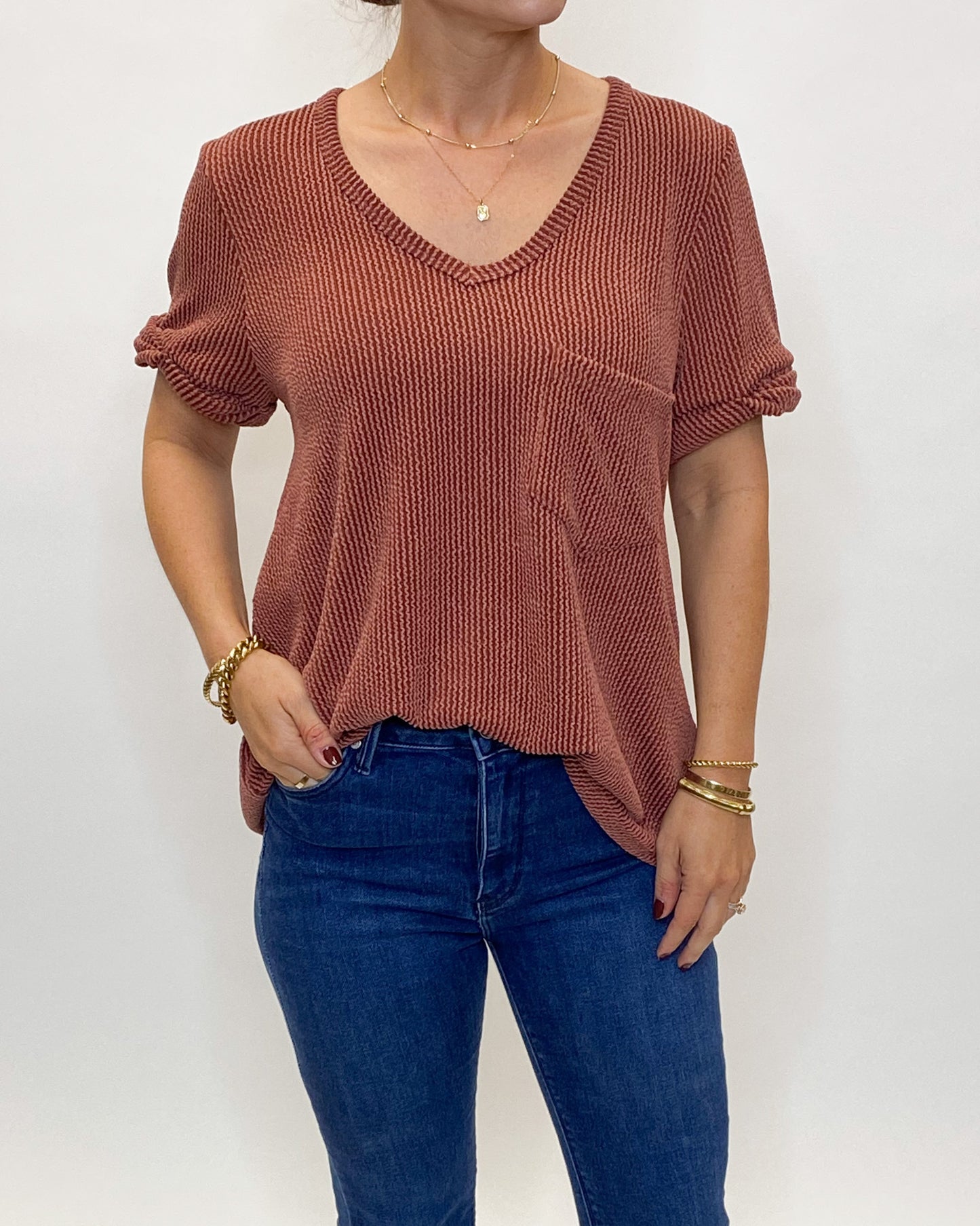 A casual rust v neck t shirt with chest pocket made of a ribbed fabric with great stretch.