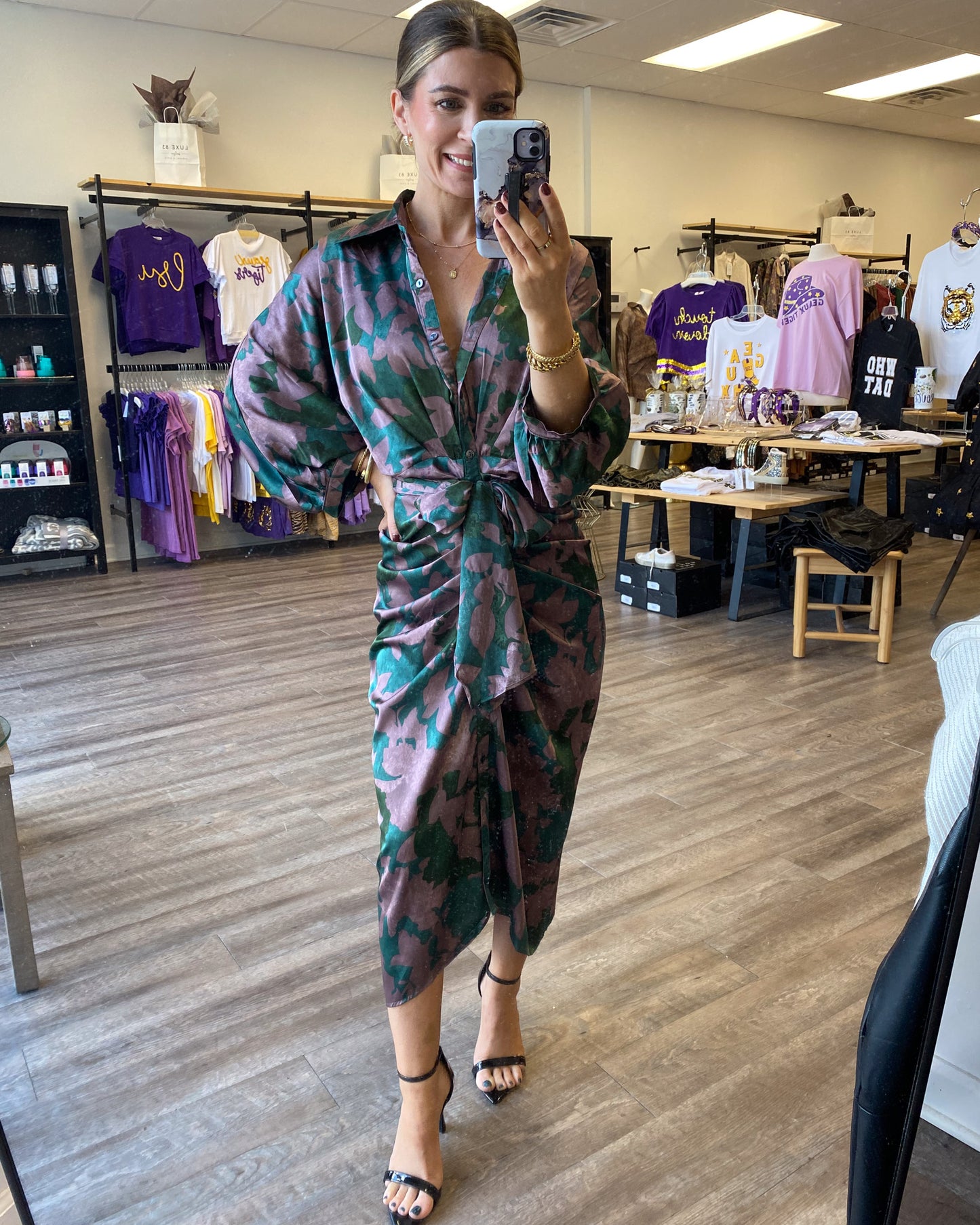 A midi length satin dress with a tie waist, and a blue, green, and purple print.