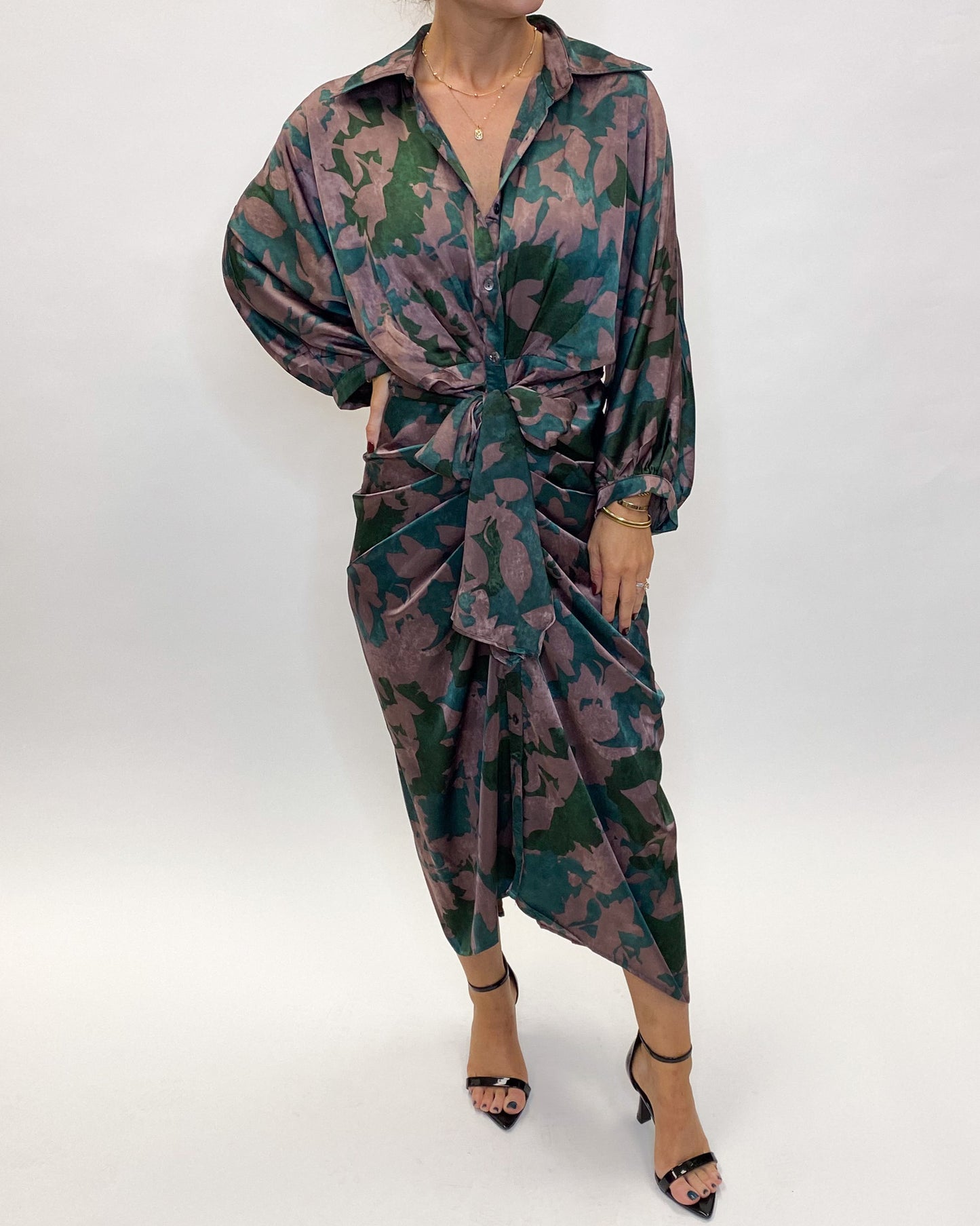 A midi length satin dress with a tie waist, and a blue, green, and purple print.