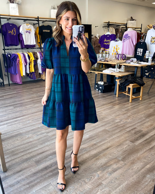 A babydoll style dress in a green and navy blue plaid print.